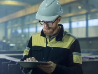 Maintenance worker in factory with tablet