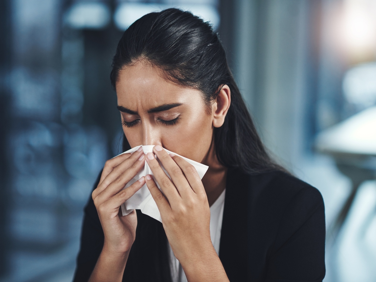 Business woman sneezing