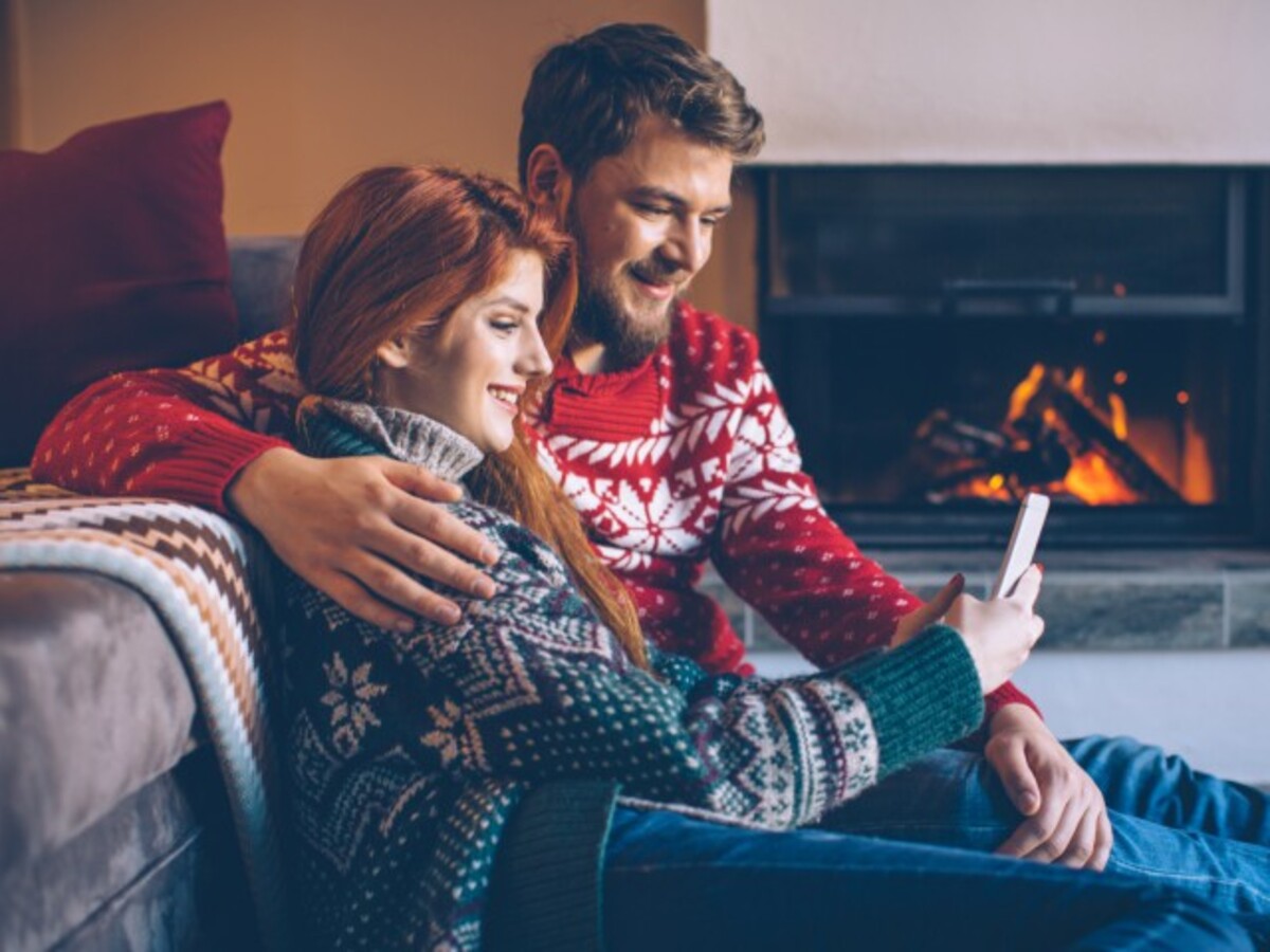 Couple sitting by warm fire in living room