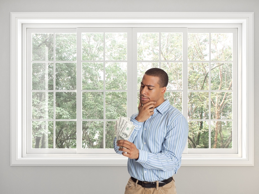 Man standing in front of window looking at money