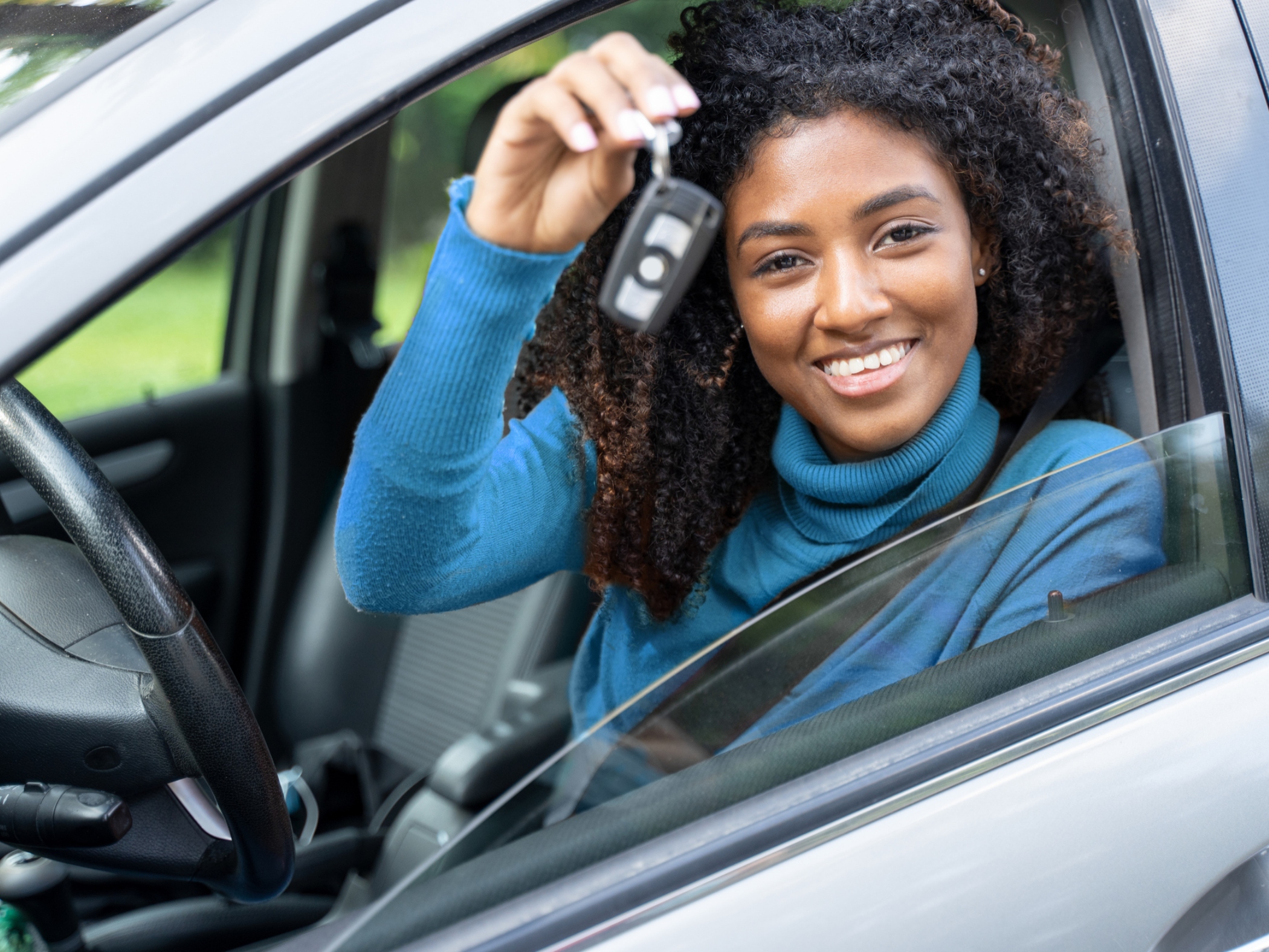 Woman holding key to new car