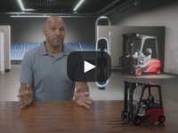 Man sitting at desk with model forklift