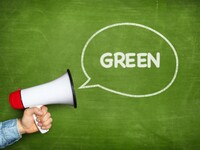 Man holding bullhorn in front of green chalkboard background