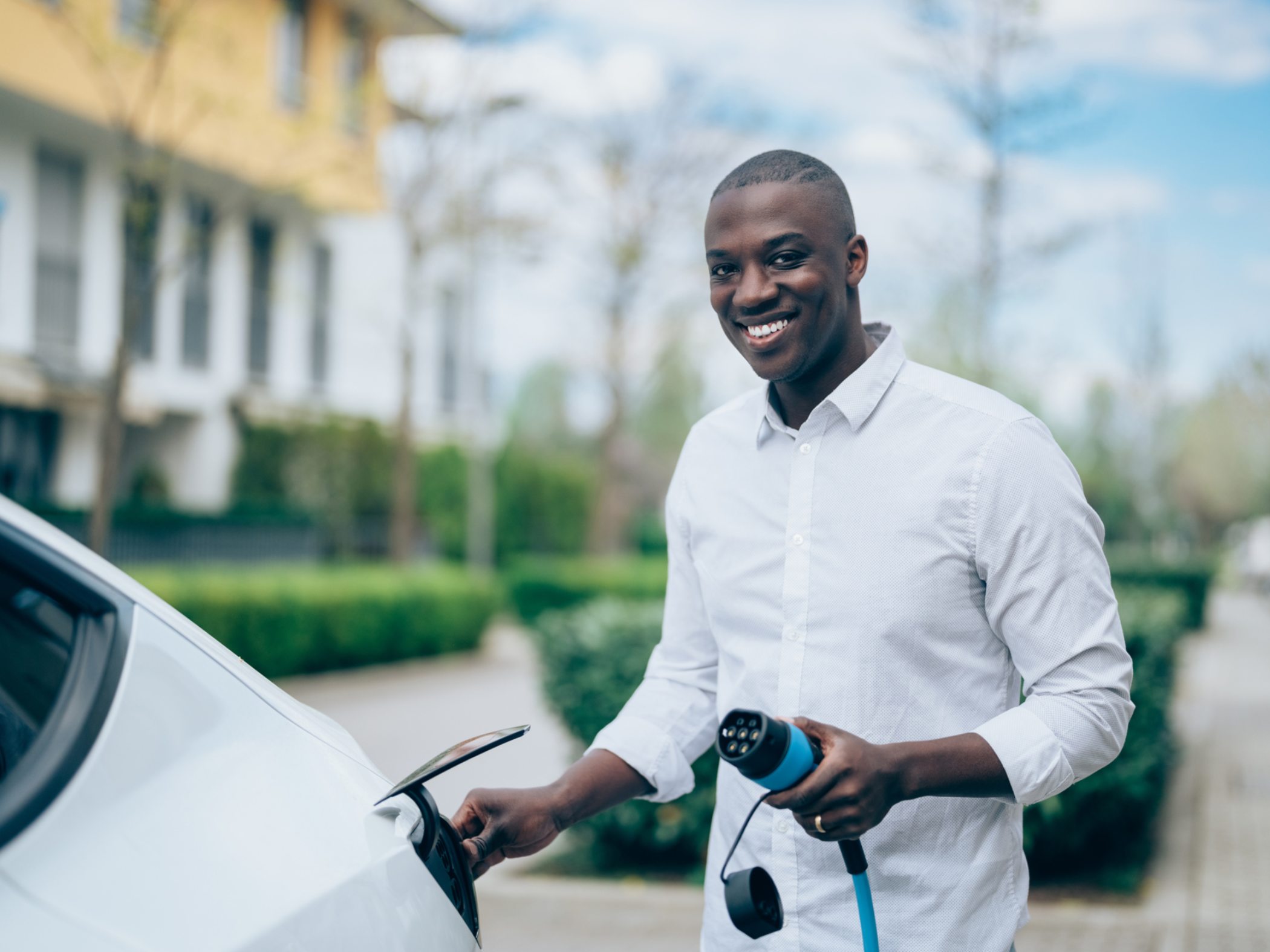 Un hombre cargando un vehículo eléctrico