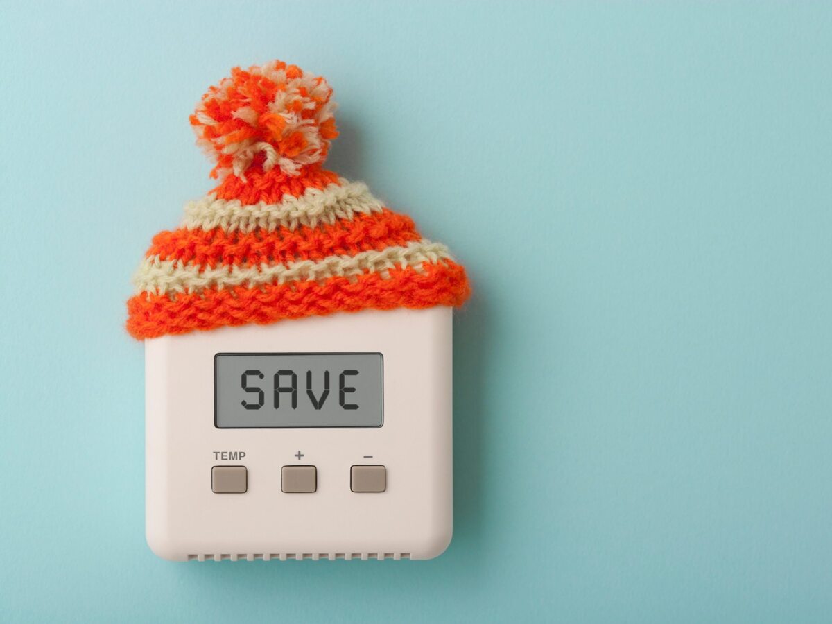 Thermostat wearing knitted cap and saying SAVE