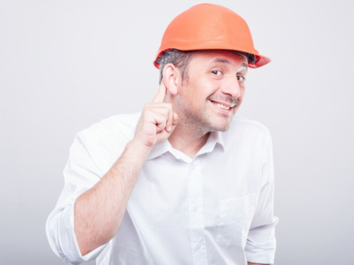 Man in hard hat trying to listen