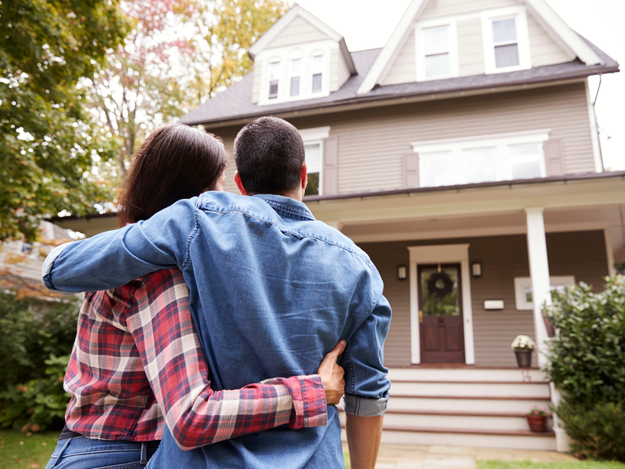 Couple looking at house from outside. 