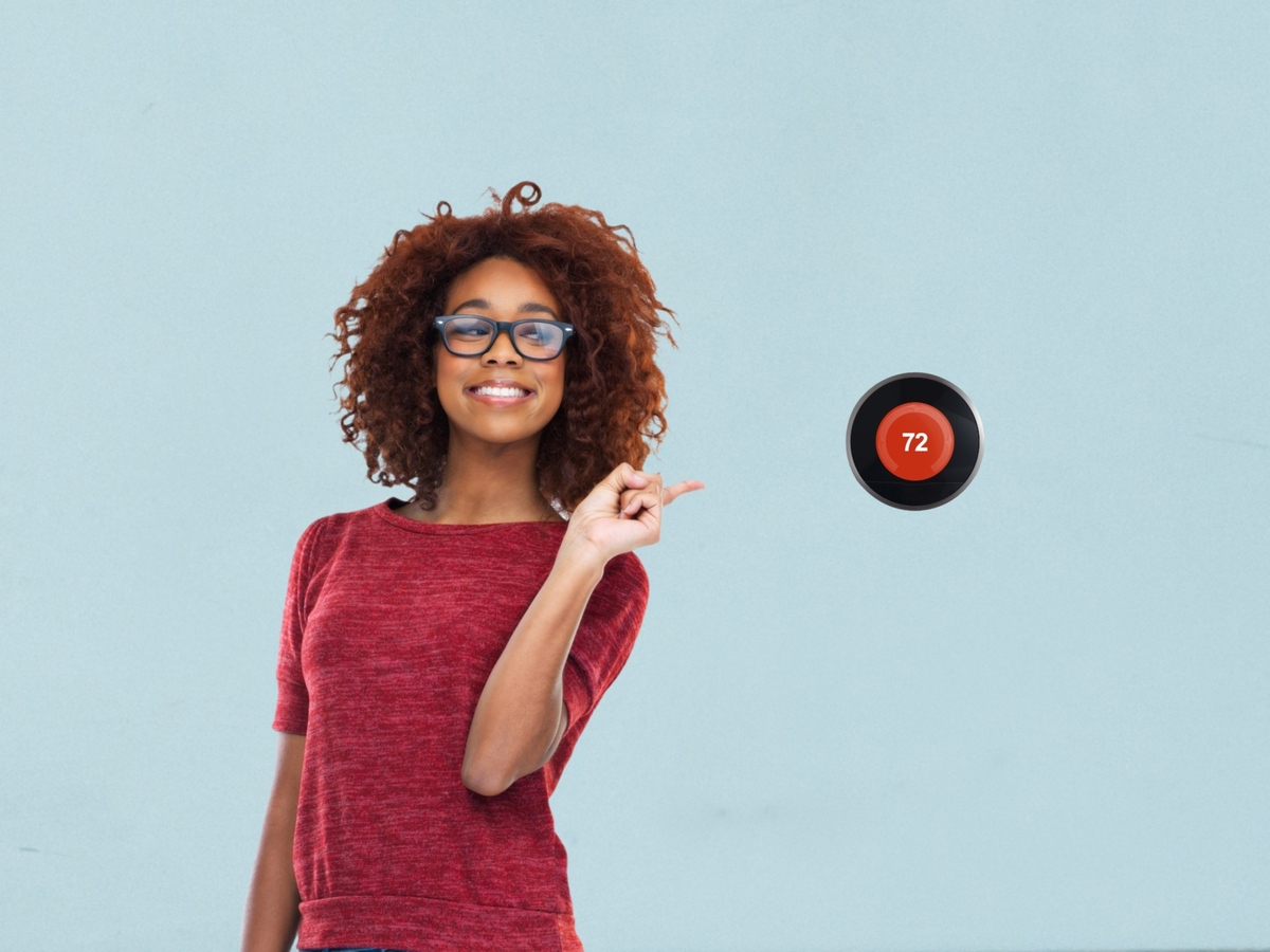 Woman pointing at thermostat