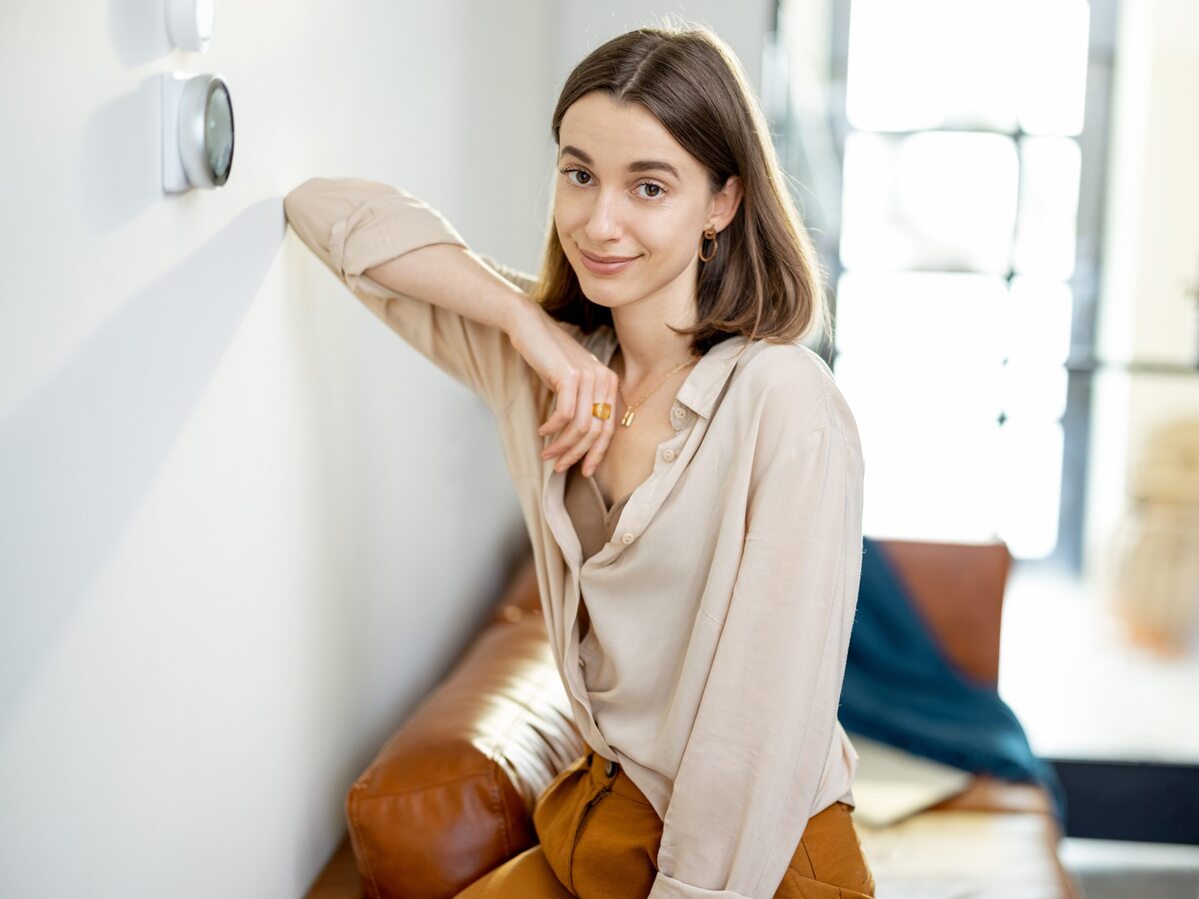 Woman standing in living near thermostat