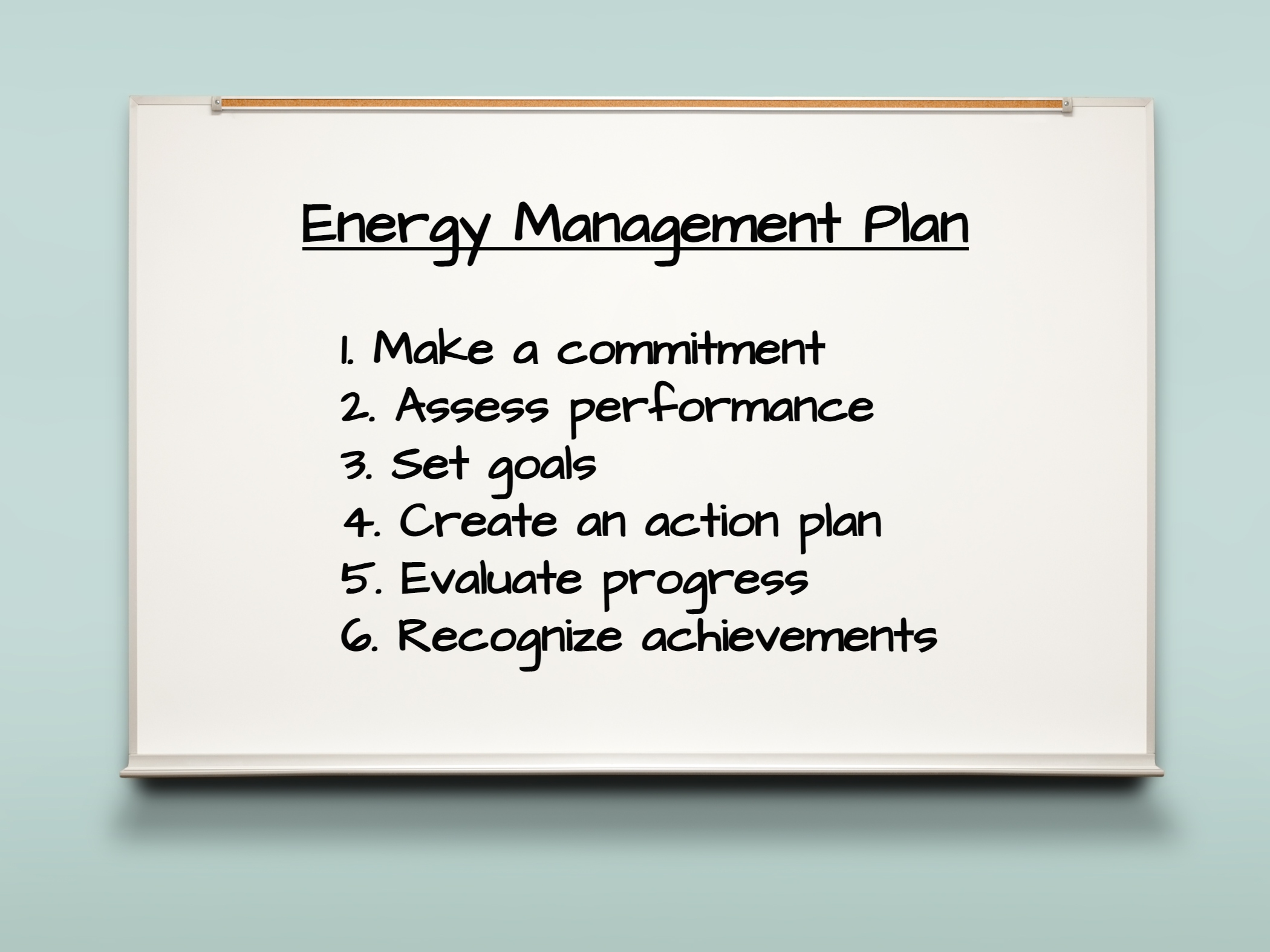 Whiteboard on wall detailing energy management plan.